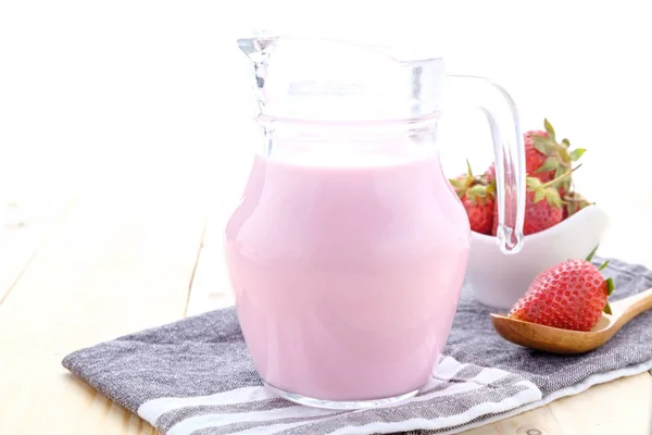 Taze çilek süt eski bir ahşap masa üzerinde yapılmış.