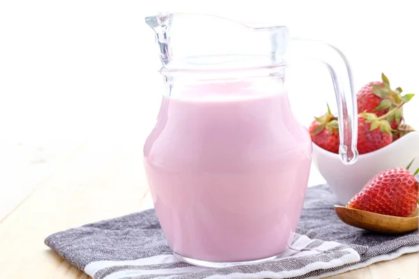 Taze çilek süt eski bir ahşap masa üzerinde yapılmış.