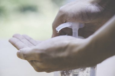 Virüsten, bakterilerden ve hijyenden el yıkama / temizleme için alkol jeli itmek ya da pompalamak. Rotine 'de fundalık ve güvenlik kavramı