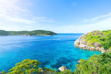 Okyanus körfezi adasını görmek için dağın zirvesinden manzara. Mavi deniz suyu gökyüzü ve sürat teknesi körfezi geçiyor.