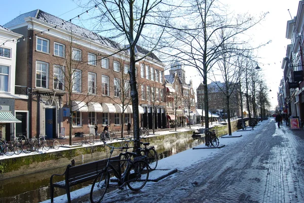 Delft, Países Bajos - personas no identificadas en la calle en una mañana soleada después de una nevada — Foto de Stock