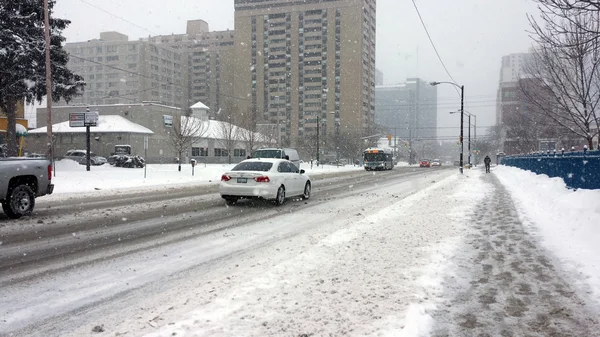 Voitures et bus conduisant sur une route glissante dans la ville en cas de fortes chutes de neige — Photo