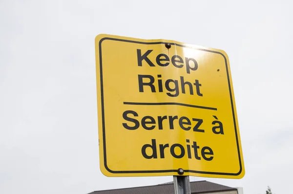 Warning traffic sign for directions in the street. French and English