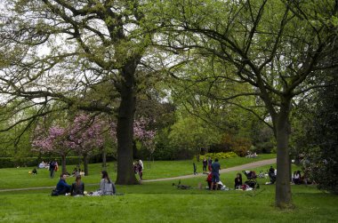 Londra, Ingiltere. 22 Nisan 2018. İnsanlar bir bulutlu par dinlenmek almak