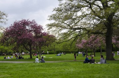 Londra, Ingiltere. 22 Nisan 2018. İnsanlar bir bulutlu par dinlenmek almak