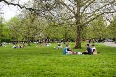 Londra, Ingiltere. 22 Nisan 2018. İnsanlar bir bulutlu par dinlenmek almak