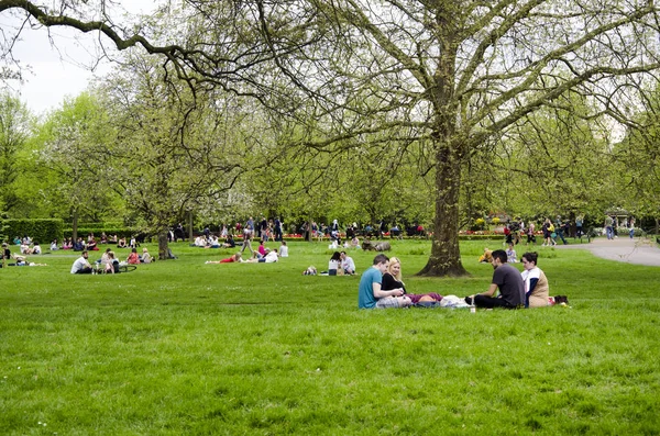 Londra, Ingiltere. 22 Nisan 2018. İnsanlar bir bulutlu par dinlenmek almak