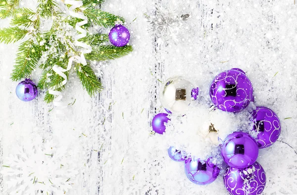 Tema de año nuevo: Árbol de Navidad, bolas de violeta y plata, nieve, copos de nieve, serpentina sobre fondo de madera estilizada retro blanco con nevadas brillantes — Foto de Stock