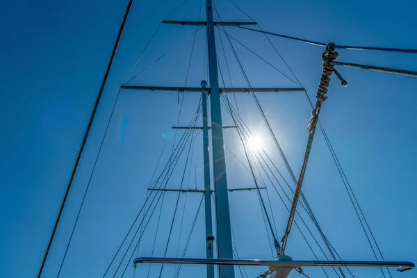 Albero dello yacht contro il cielo blu con bagliore del sole — Foto Stock