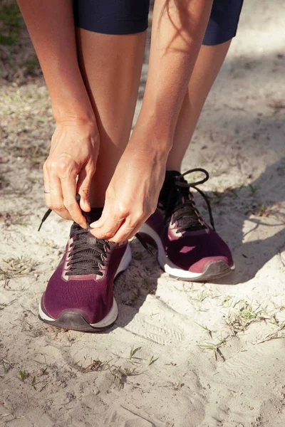 Primer Plano Una Mujer Atando Cordones Zapatillas Deporte Mientras Camina — Foto de Stock