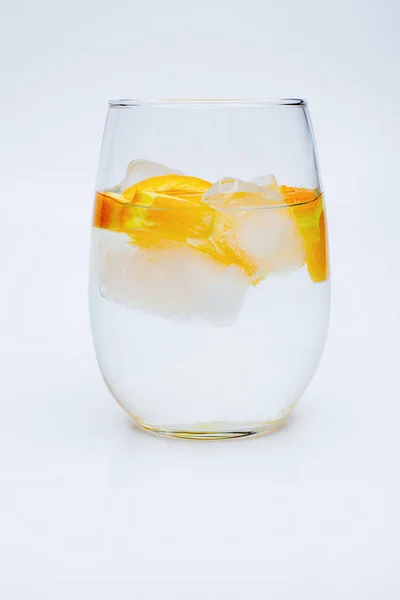 Glasbecher Mit Wasser Eisstücken Und Orangenscheiben Auf Weißem Hintergrund — Stockfoto