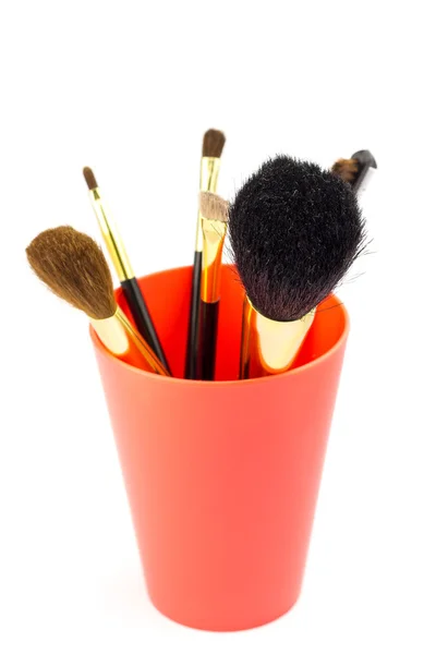 Cepillos cosméticos profesionales para maquillaje en soporte rojo, sobre fondo blanco — Foto de Stock