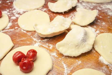 Ev yapımı Ukraynalı köfte veya varenyky, kiraz ile hamur yuvarlak parçalar kesilmesi hazırlanıyor
