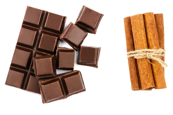 Mörk chokladkaka, kuber och kanelstänger isolerad på vit bakgrund, ovanifrån. — Stockfoto