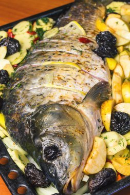 Sazan balık sebze ile pişirme çanağı içinde yemek pişirmek için hazırlanan.