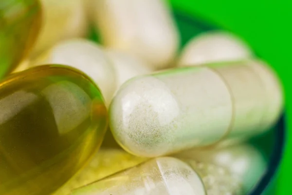 混合的天然食品补充药片、 欧米茄 3 和氨基葡萄糖胶囊对绿色背景. — 图库照片