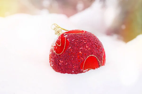 Red Christmas ball lying on natural white snow, Christmas Background. — Stock Photo, Image