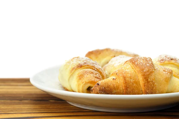 Bagels frais faits maison dans une assiette sur fond bois et blanc . — Photo