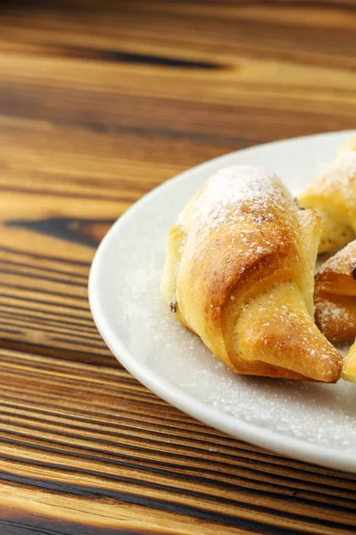 Bagels frais faits maison dans une assiette blanche sur fond en bois . — Photo