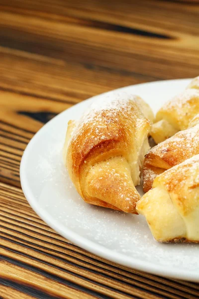 Bagel freschi fatti in casa in piatto bianco su sfondo di legno . — Foto Stock