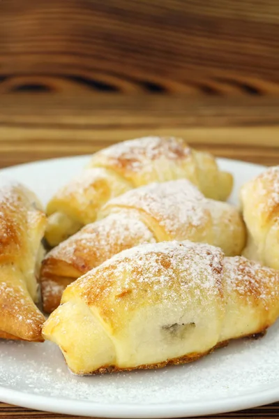 Bagel freschi fatti in casa in piatto bianco su sfondo di legno . — Foto Stock