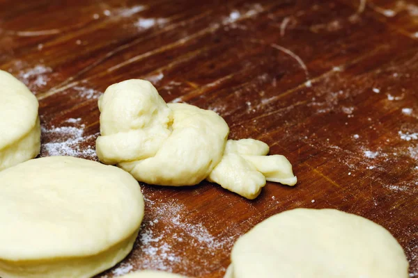 Petites boules de pâte fraîche maison et une en forme d'oiseau pour les beignets sur une planche en bois . — Photo