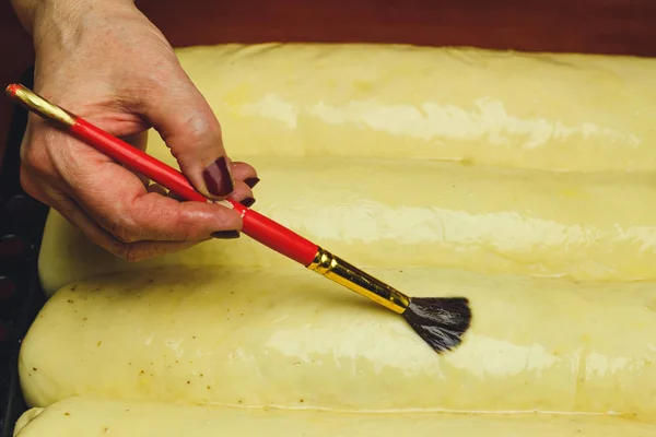 Processus de fabrication de tarte strudel, femme lubrifie jaune d'oeuf la pâte . — Photo