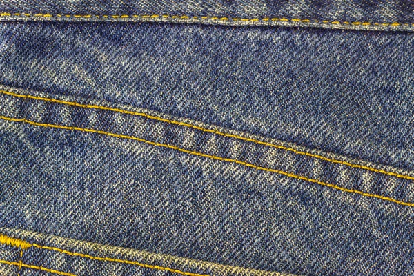 Calça jeans azul com costura, fundo textura denim, close-up . — Fotografia de Stock