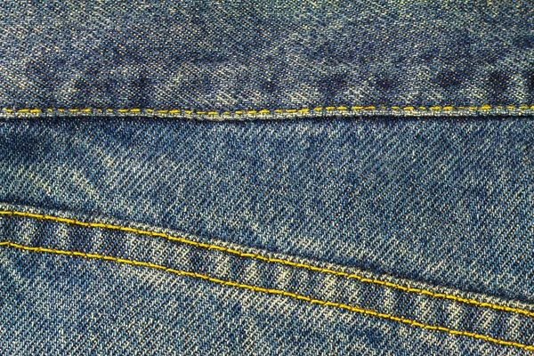 Blue jeans met naad, denim textuur achtergrond, close-up. — Stockfoto