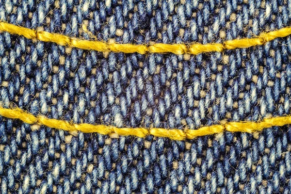 Macro image of blue jeans interwoven gold thread, denim texture background. — Stock Photo, Image