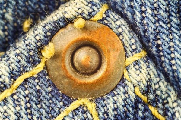 Металлическая кнопка на синих джинсах, высокое увеличение макроизображения . — стоковое фото