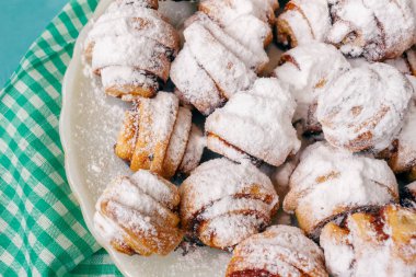 Ev yapımı taze kurabiye silkeledi şekere de beyaz tabakta ahşap mavi arka plan ve peçete.