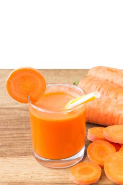 Bardakta taze havuç suyu, saman ve ahşap masa üzerinde havuç ve beyaz arka plan.