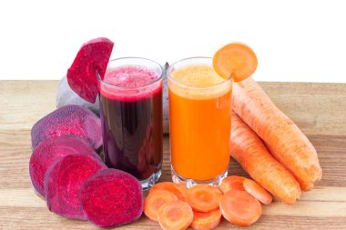 İki bardak taze pancar ve havuç suyu, pancar kökü ve havuç, ahşap masada sebze, beyaz arka plan.