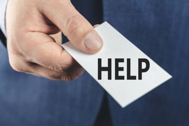 Mavi takım elbiseli bir iş adamı, yakın çekimde mesaj yardımıyla kartı gösteriyor.