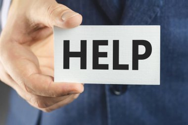 Mavi takım elbiseli bir iş adamı, yakın çekimde mesaj yardımıyla kartı gösteriyor.