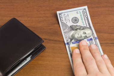 Adam elini ahşap arka plan, yakın plan, para ve finans konseptine koydu.