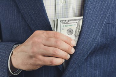 İş adamı cebine 100 dolar para koydu, rüşvet konsepti.