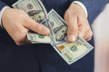 Erkek ellerine yakın plan 100 dolarlık banknotlar, iş ve finans kavramı