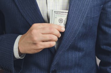 İş adamı cebine 100 dolar para koydu, rüşvet konsepti.