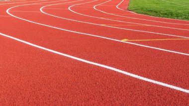 Spor stadyumunda kırmızı koşu pisti ve beyaz şeritler.