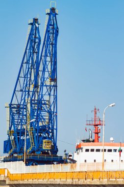 Bulgaristan 'ın Balchik kentindeki deniz limanında vinçleri olan büyük bir kargo gemisi..