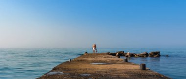 Baba ve küçük bebeği iskelede. Denize bak..