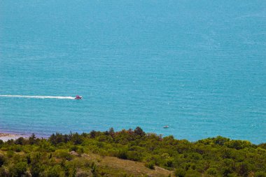 Tepeden deniz manzarası, güneşli yaz gününde gökteki kayıklar..