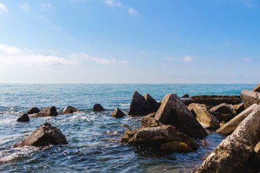 Karadeniz kıyısında deniz manzarası, ön planda güneşli yaz gününde mavi suda büyük taşlar..