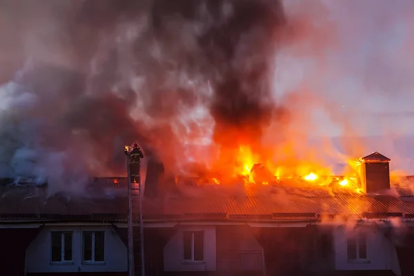 Şehrin çatısı dumanla alev alev yanıyor. İtfaiyeci ya da itfaiyeci yangını söndürüyor..