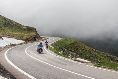 Avrupa 'nın en ünlü ve tehlikeli yolunda seyahat eden bisikletçi ve bisikletçi Romanya' nın Karpatya dağlarındaki Transfagarasan yolu.