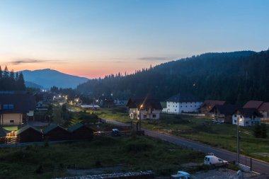 Romanya 'nın alacakaranlıkta gün batımından sonra Karpat dağlarındaki Voronets köyü.