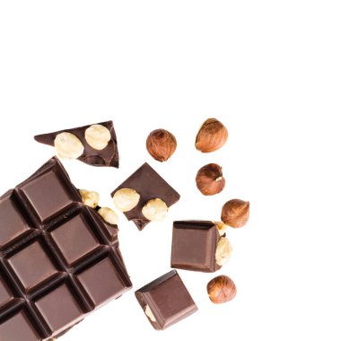 Beyaz arka planda izole edilmiş fındıklı acı siyah çikolata küpleri..