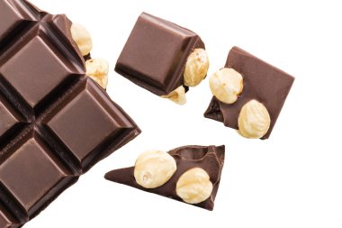 Beyaz arka planda izole edilmiş fındıklı acı siyah çikolata küpleri..